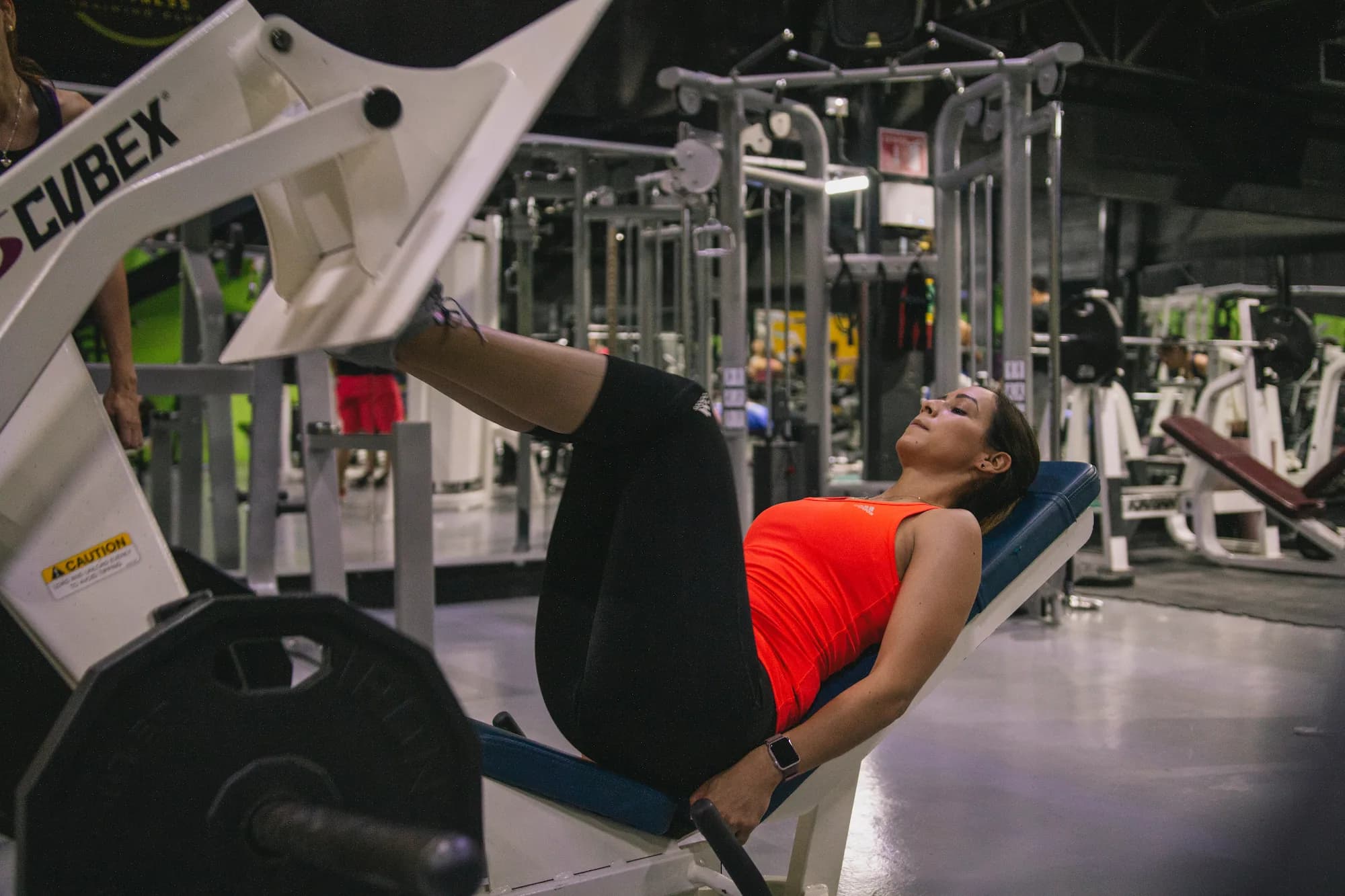 Cliente entrenando en prensa de pierna en el gym